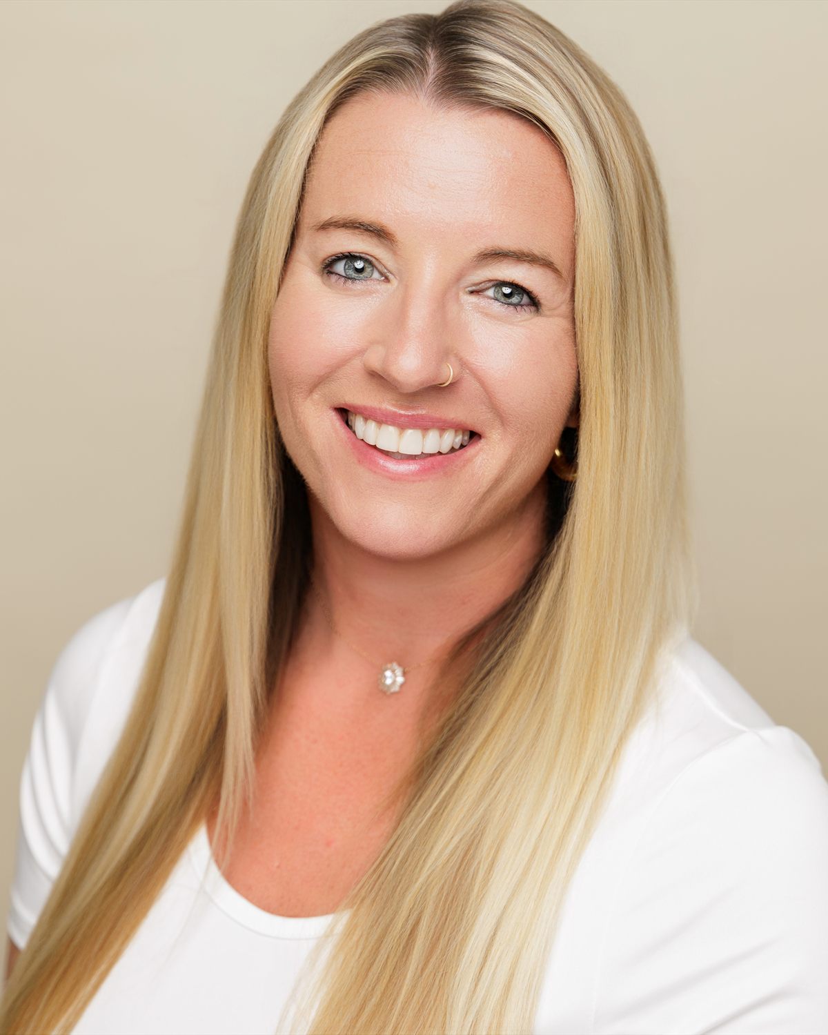 Johnell Arnett, founder of HostWell Consulting and Planning, photographed in a white top against a warm cream backdrop.